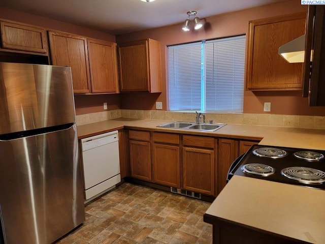 kitchen featuring black electric range oven, sink, stainless steel refrigerator, and dishwasher