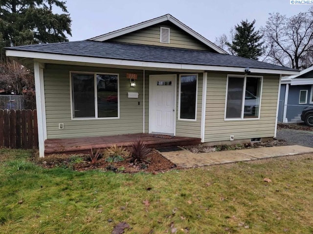 bungalow-style home with a front yard and covered porch