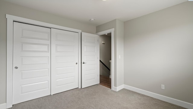 unfurnished bedroom featuring carpet flooring, a closet, and baseboards