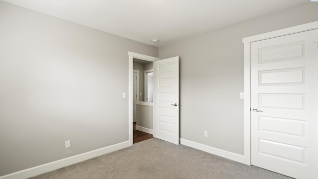 unfurnished bedroom featuring light carpet and baseboards