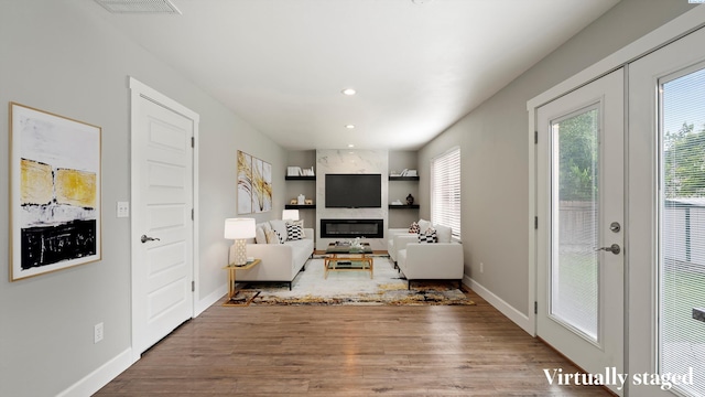 living room with french doors, baseboards, wood finished floors, recessed lighting, and built in features