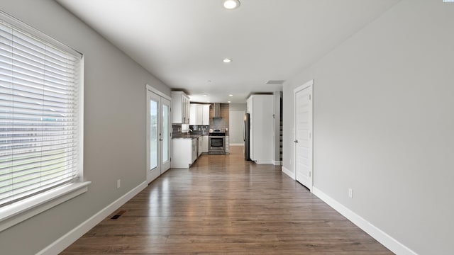 unfurnished living room featuring dark wood-style floors, recessed lighting, and baseboards