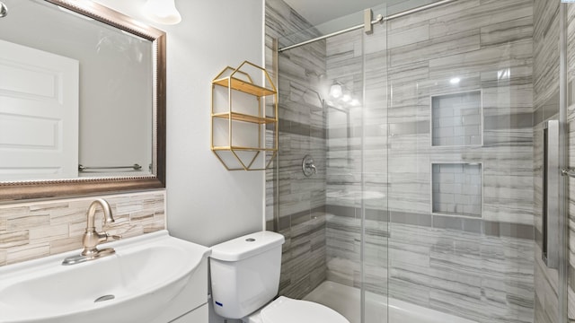 bathroom with toilet, tasteful backsplash, a shower stall, and vanity