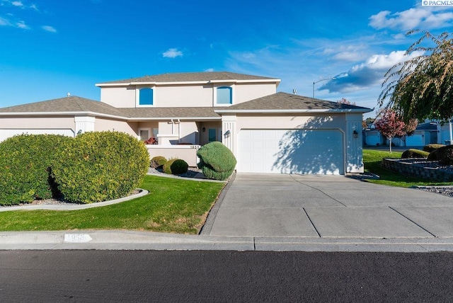 view of front of house with concrete driveway, a front yard, an attached garage, and stucco siding