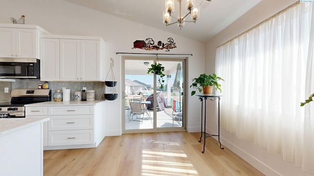 1609 Diamond Ave, Grandview, WA 98930 - kitchen with stainless steel appliances, vaulted ceiling, backsplash, a chandelier, and light wood finished floors