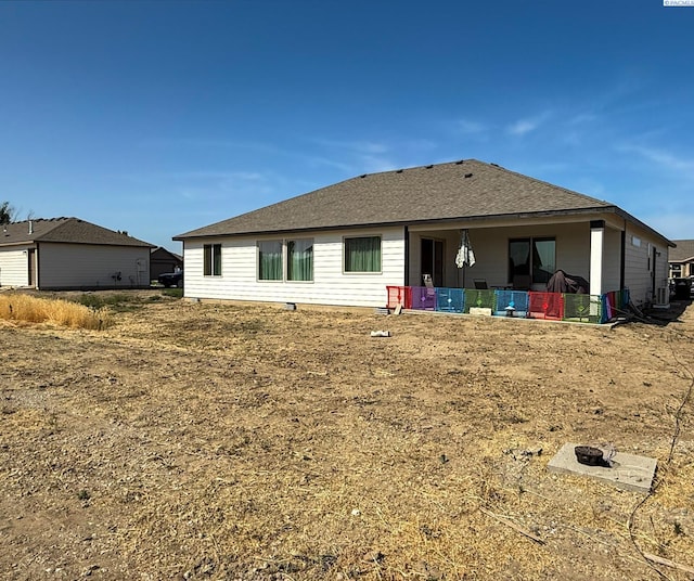 1609 Diamond Ave, Grandview, WA 98930 - rear view of house with a fire pit and a shingled roof