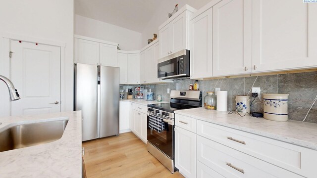 1609 Diamond Ave, Grandview, WA 98930 - kitchen with stainless steel appliances, white cabinets, light stone counters, and backsplash