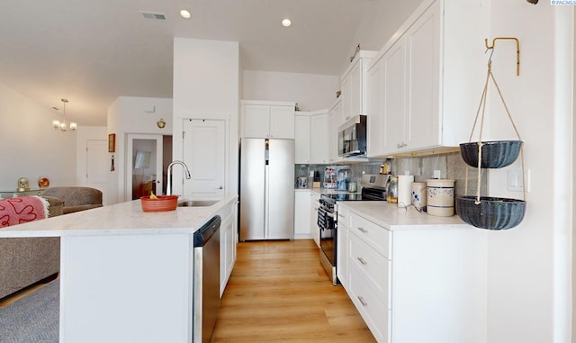 1609 Diamond Ave, Grandview, WA 98930 - kitchen featuring stainless steel appliances, light countertops, white cabinetry, a chandelier, and backsplash