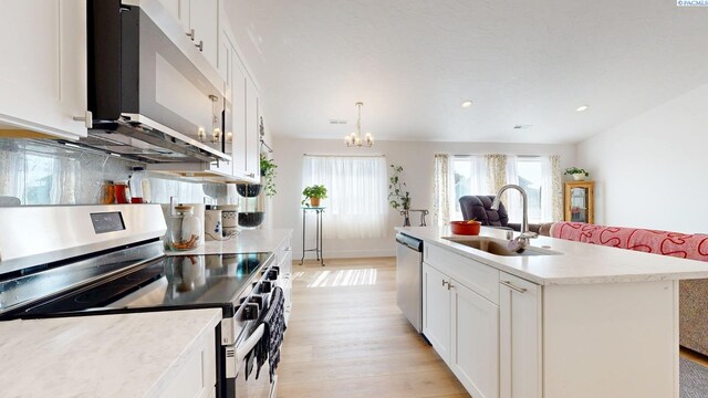 1609 Diamond Ave, Grandview, WA 98930 - kitchen featuring appliances with stainless steel finishes, light wood-type flooring, a chandelier, light countertops, and white cabinets