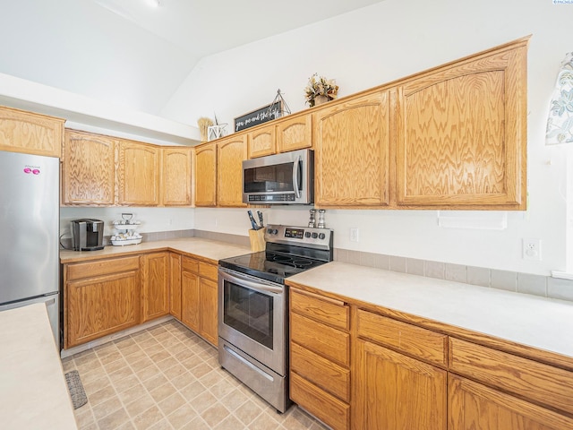 612 S Young St, Kennewick, WA 99336 - kitchen featuring appliances with stainless steel finishes, light countertops, and vaulted ceiling