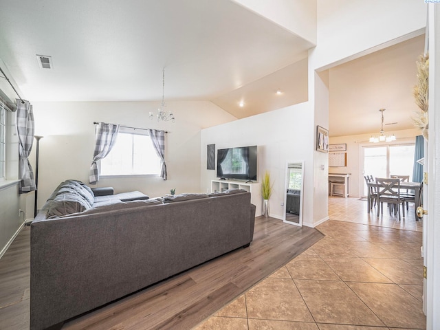 612 S Young St, Kennewick, WA 99336 - living area featuring a chandelier, vaulted ceiling, tile patterned flooring, and baseboards