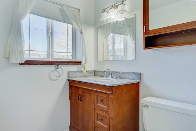 half bath featuring vanity and toilet