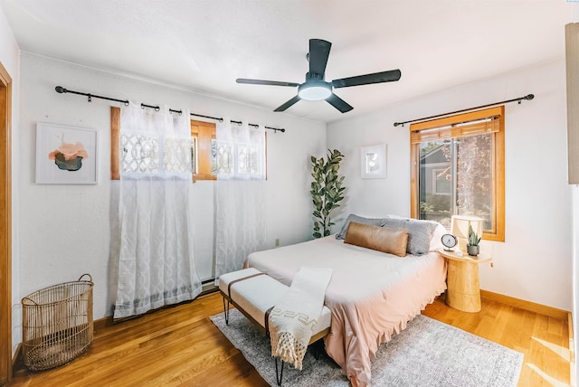 1830 Hunt Pt, Richland, WA 99354 - bedroom with wood finished floors, a ceiling fan, a baseboard heating unit, and baseboards