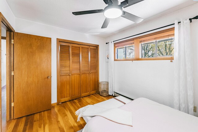 1830 Hunt Pt, Richland, WA 99354 - bedroom with a baseboard radiator, a closet, wood finished floors, and ceiling fan