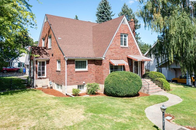 912 S Lake St, Colfax, WA 99111 - view of side of property featuring a chimney, a yard, brick siding, and roof with shingles