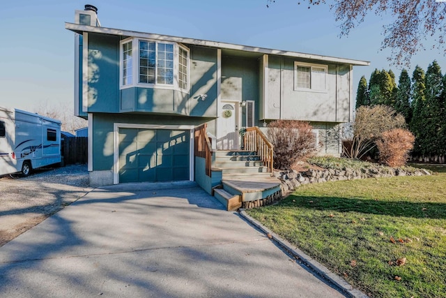 split foyer home with a garage and a front lawn