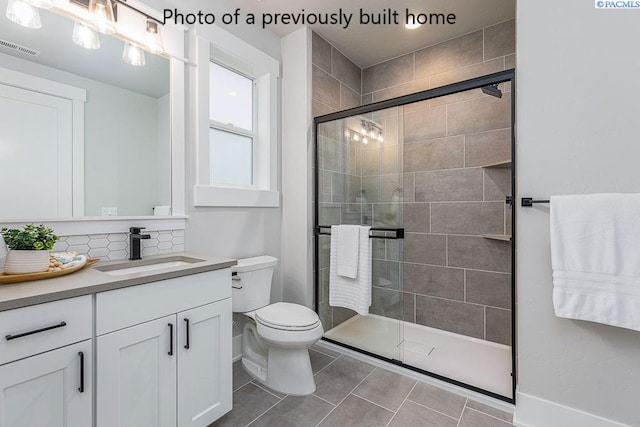 bathroom with backsplash, tile patterned flooring, vanity, an enclosed shower, and toilet