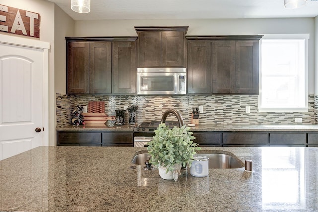 1390 Jade Ave, West Richland, WA 99353 - kitchen with stainless steel appliances, dark brown cabinetry, tasteful backsplash, light stone counters, and a sink