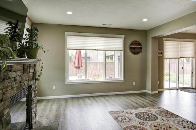 1390 Jade Ave, West Richland, WA 99353 - unfurnished living room featuring wood finished floors, a fireplace, baseboards, and recessed lighting