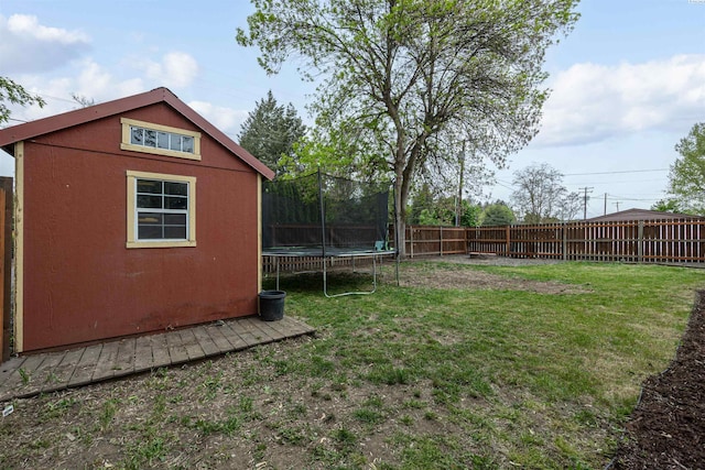 view of yard featuring a trampoline and a storage unit