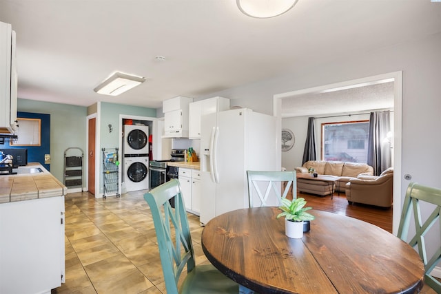 dining area featuring stacked washer / drying machine and sink