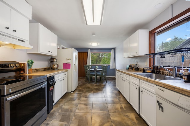 kitchen featuring tile countertops, white cabinetry, sink, dark tile patterned floors, and white appliances