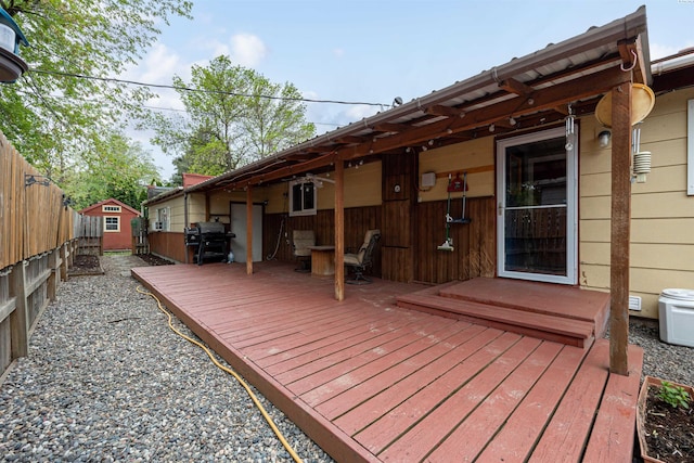 wooden deck with grilling area and a storage unit