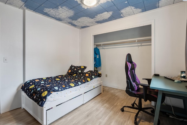 bedroom featuring hardwood / wood-style floors and a closet