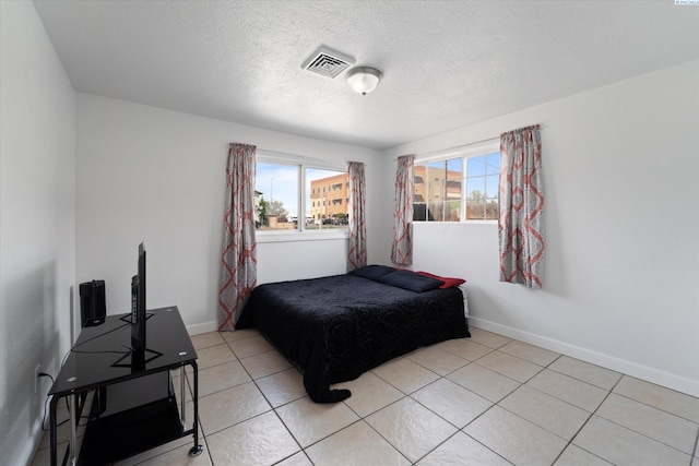 bedroom featuring baseboards, multiple windows, and visible vents