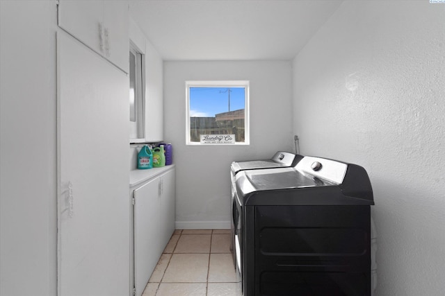 laundry area featuring light tile patterned flooring, laundry area, washing machine and dryer, and baseboards