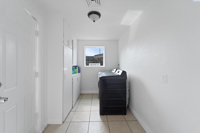 washroom with laundry area, visible vents, washing machine and clothes dryer, light tile patterned floors, and baseboards