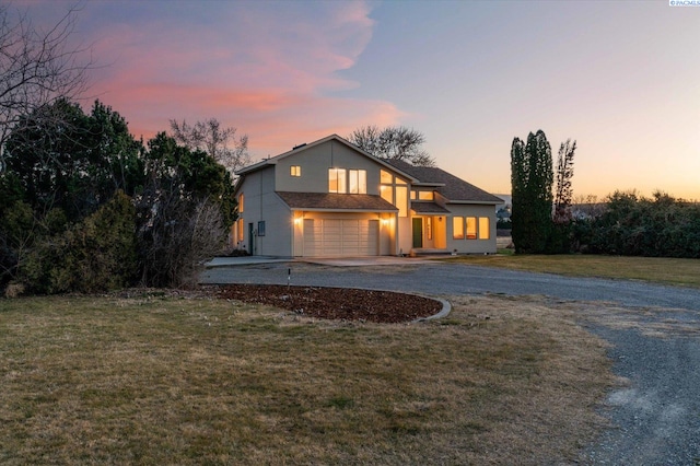 view of front of house with a garage, driveway, and a front lawn