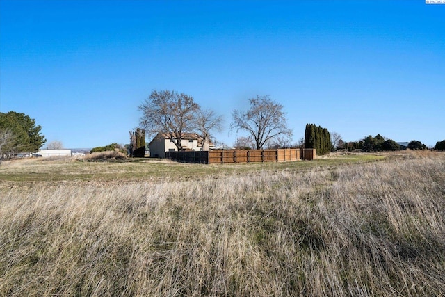 view of yard with a rural view and fence