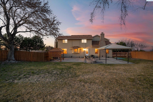 rear view of house featuring a patio area, a yard, a fenced backyard, and a gazebo