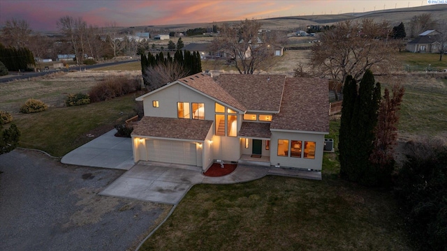 view of front of house featuring a garage, concrete driveway, and a front lawn