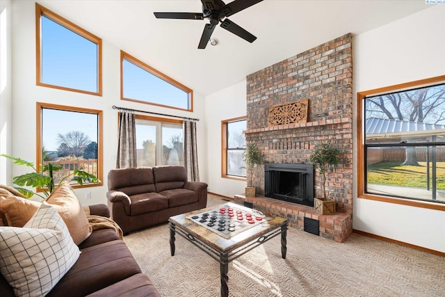 carpeted living area featuring high vaulted ceiling, a brick fireplace, a ceiling fan, and baseboards