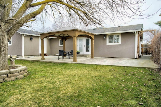 back of property with a patio, a lawn, fence, and stucco siding