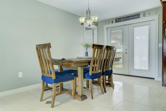 dining area featuring light tile patterned flooring, a notable chandelier, french doors, and baseboards