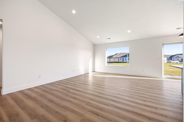 unfurnished room with baseboards, light wood finished floors, recessed lighting, and a healthy amount of sunlight