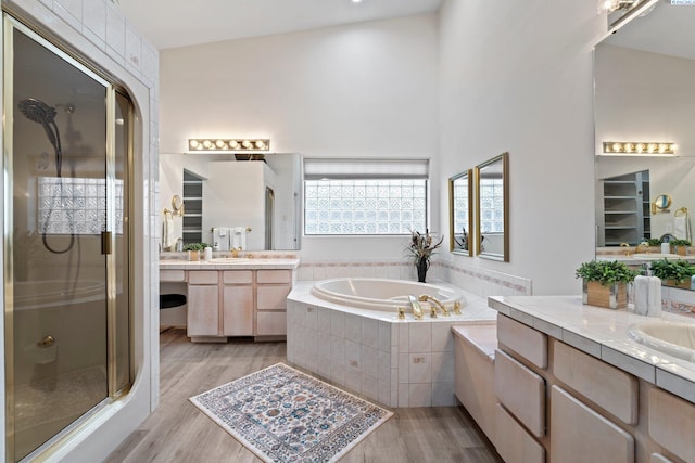 bathroom with vanity, shower with separate bathtub, and hardwood / wood-style floors