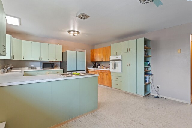 1506 Wilson St, Richland, WA 99354 - kitchen with stainless steel microwave, oven, freestanding refrigerator, a peninsula, and light floors