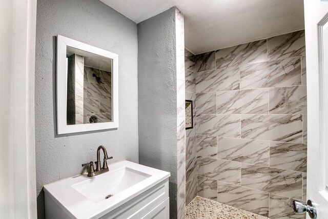 503 Grandridge Ave, Grandview, WA 98930 - bathroom with a tile shower, a textured wall, and vanity