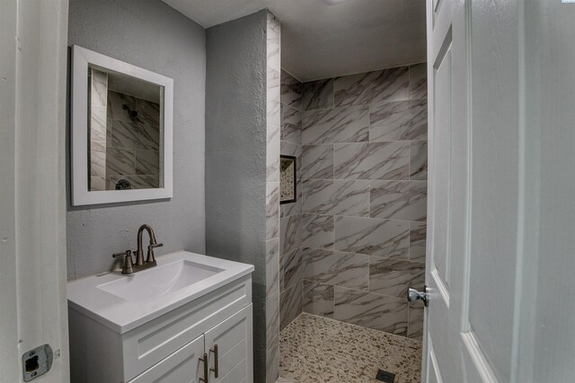 503 Grandridge Ave, Grandview, WA 98930 - bathroom featuring a tile shower, vanity, and a textured wall
