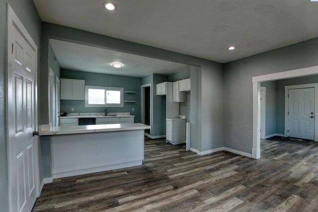 503 Grandridge Ave, Grandview, WA 98930 - kitchen with dark wood-style floors, a peninsula, baseboards, and white cabinetry