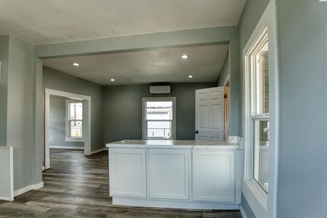 503 Grandridge Ave, Grandview, WA 98930 - kitchen with baseboards, a wall mounted air conditioner, recessed lighting, a peninsula, and dark wood-type flooring