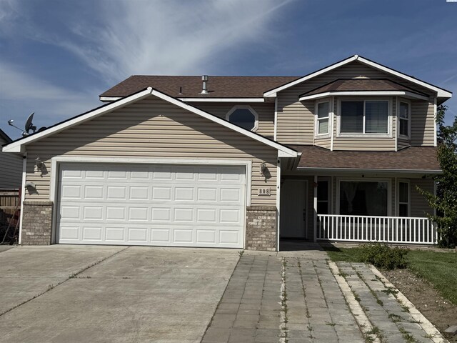 808 N Owen Ave, Pasco, WA 99301 - view of front of property with a porch, driveway, a garage, roof with shingles, and brick siding