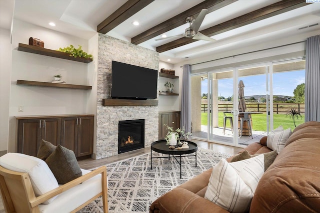 3905 Orchard St, West Richland, WA 99353 - living area featuring beamed ceiling, light wood-style floors, a stone fireplace, a ceiling fan, and recessed lighting