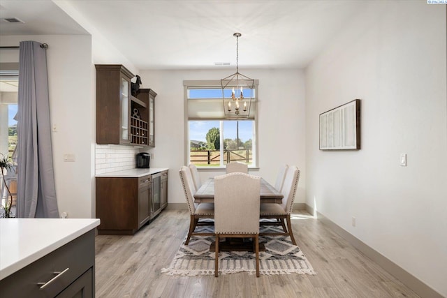 3905 Orchard St, West Richland, WA 99353 - dining space featuring a chandelier, light wood-type flooring, baseboards, and wine cooler