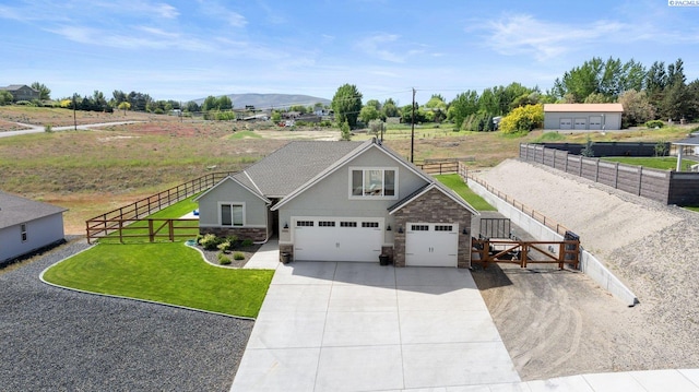 3905 Orchard St, West Richland, WA 99353 - view of front facade with stone siding, concrete driveway, a garage, and a mountain view