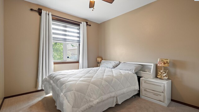 bedroom with baseboards, a ceiling fan, and light carpet